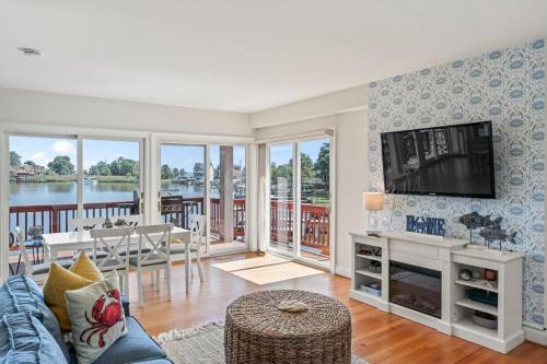 a living room with a couch and a tv and a table at Waterfront Getaway - Dock UR Boat & Walk to Beach in Annapolis