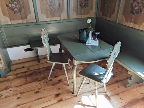 a table with two chairs and a table with a vase at Schloss Mörlbach in Icking