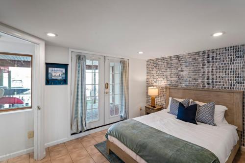 a bedroom with a large bed with a brick wall at Waterfront Getaway - Dock UR Boat & Walk to Beach in Annapolis