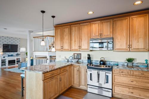 a kitchen with wooden cabinets and marble counter tops at Waterfront Getaway - Dock UR Boat & Walk to Beach in Annapolis