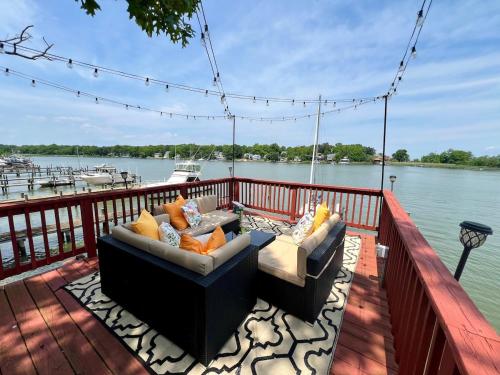 a deck with two couches and a view of the water at Waterfront Getaway - Dock UR Boat & Walk to Beach in Annapolis