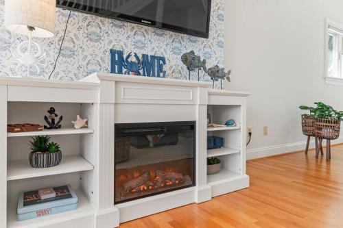 a white entertainment center with a fireplace in a living room at Waterfront Getaway - Dock UR Boat & Walk to Beach in Annapolis