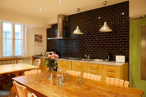 a kitchen with a wooden table with chairs and a sink at Schloss Mörlbach in Icking