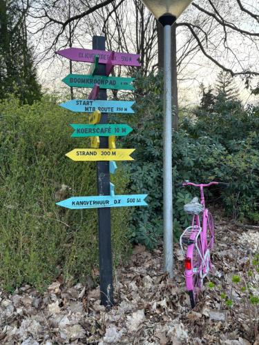 a street sign with many signs on it with a bike at Chalet Drentse Lente in Gasselte