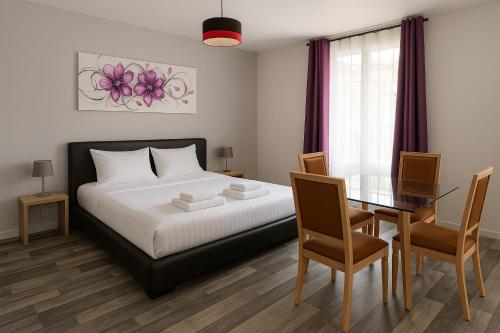 une chambre avec un lit et une table avec des chaises dans l'établissement Appart du cirque centre historique, à Troyes