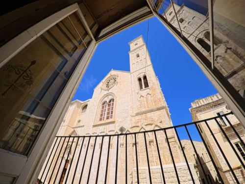 a clock tower seen through the window of a building at Palazzo Framarino dei Malatesta - Noble Floor - XIV Century in Giovinazzo