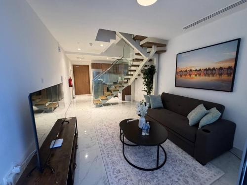 Una sala de estar con un sofá y una escalera. en Unique 2bd Jacuzzi & Sunbed, en Abu Dabi
