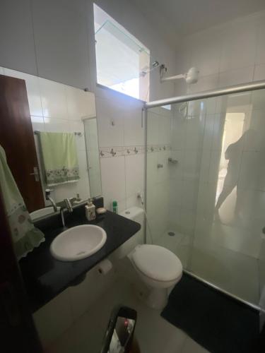 a bathroom with a toilet and a sink and a shower at Apartamento em Alagoinhas in Alagoinhas