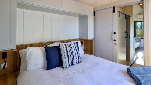 a bedroom with a bed with blue and white pillows at The Gatwick Cabin With Airport Parking Available in Horley