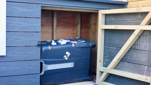 a blue suitcase sitting inside of a building at The Gatwick Cabin With Airport Parking Available in Horley