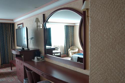 a hotel room with a mirror and a bedroom at Hotel Monaco in Mexico City
