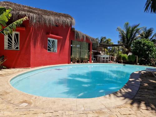 a swimming pool in front of a red house at la maison rouge in Toliara