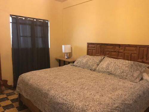 a bedroom with a bed and a window at La Adornada Girasol in Taxco de Alarcón