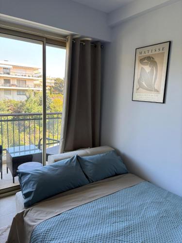 une chambre avec un lit et une grande fenêtre dans l'établissement Cannes Blue Riviera Luxe, à Cannes
