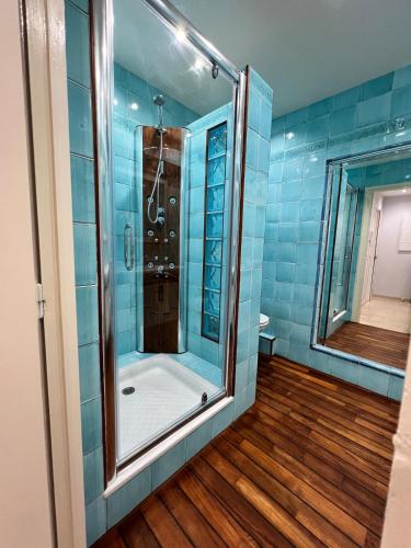 La salle de bains est pourvue d'une douche et de carrelage bleu. dans l'établissement Cannes Blue Riviera Luxe, à Cannes