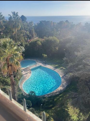 une vue aérienne d'une piscine avec l'océan en arrière-plan dans l'établissement Cannes Blue Riviera Luxe, à Cannes