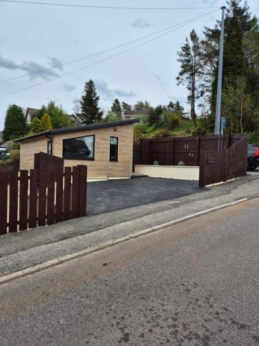 a house on the side of a road with a fence at Lanark Apartment in Fort William