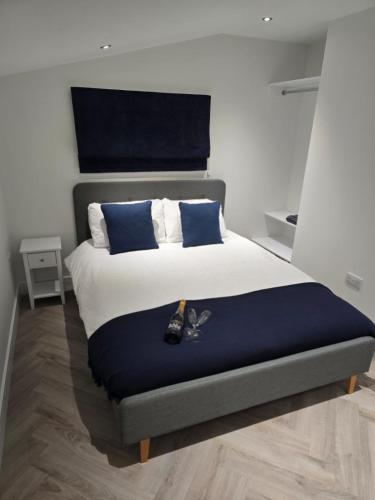 a bed with blue and white sheets and blue pillows at Lanark Apartment in Fort William