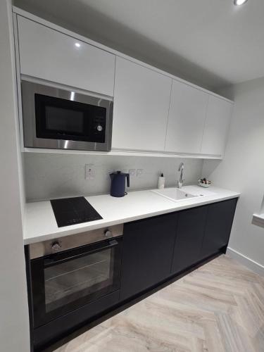 a kitchen with a sink and a microwave at Lanark Apartment in Fort William