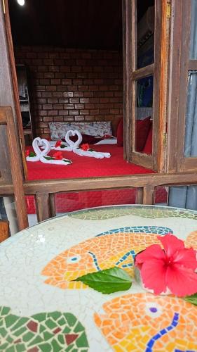 a table with flowers on it in a room at Pousada Capim Açu in Fernando de Noronha