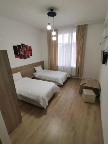 a hotel room with two beds and a window at Hotel Tatul in Momchilgrad
