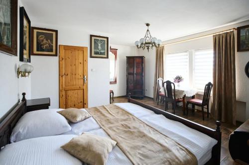 a bedroom with a large bed and a dining room at Apartamenty Pod Kalwarią Góra Św Anny in Góra Świętej Anny