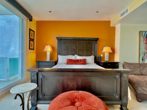 a bedroom with a bed with an orange wall at Oceanfront Villa 4BR 4 BA Real Mediterraneo in Tijuana