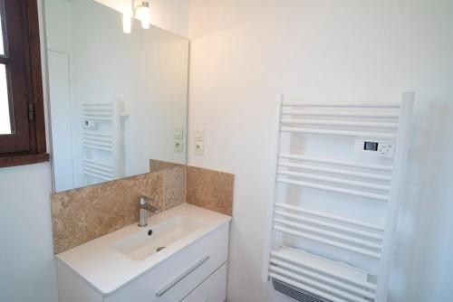 une salle de bain avec un lavabo et un miroir dans l'établissement T2 Giens-les-Plages, à Hyères