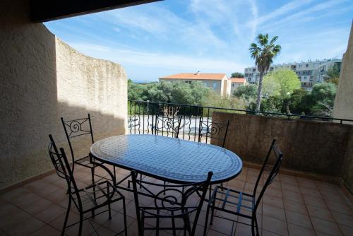 un patio avec une table et des chaises sur un balcon dans l'établissement T2 Giens-les-Plages, à Hyères