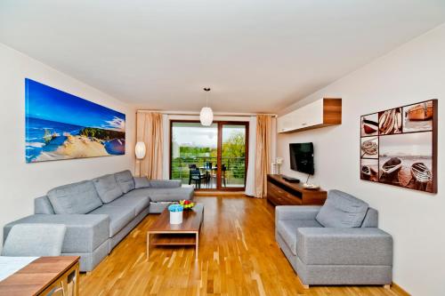 a living room with a couch and a table at BlueApart Apartamenty Na Klifie in Władysławowo