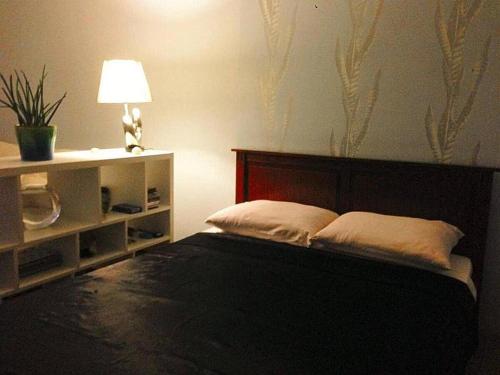 1 dormitorio con 1 cama con cabecero y lámpara en Designer Apartment in Old Town, en Sarajevo