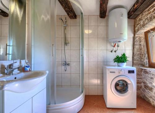 a bathroom with a shower sink and a washing machine at Haus Ana in Mali Ježenj