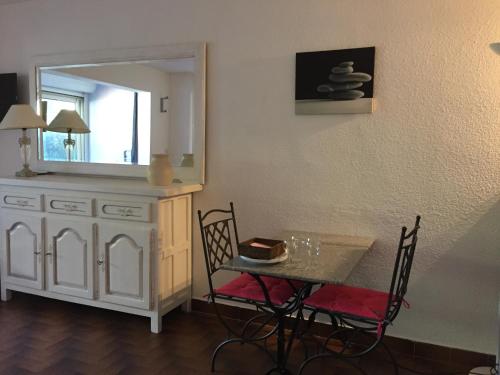 une salle à manger avec une table et un miroir dans l'établissement Grand studio mer piscine, à Bandol
