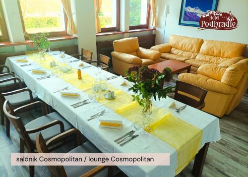 a room with a long table with chairs and a couch at Hotel Podhradie in Považská Bystrica