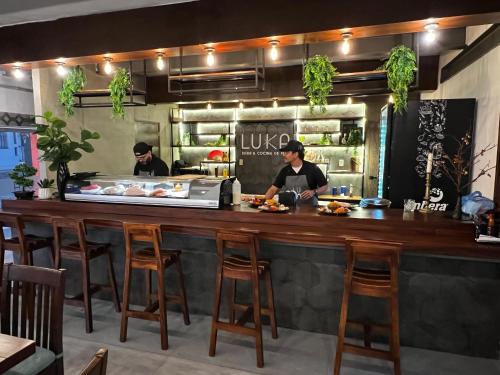 two chefs preparing food at a counter in a restaurant at Hotel La Siesta Malecón in Mazatlán