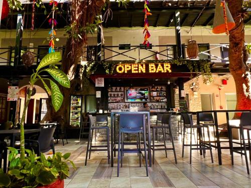 a bar with chairs and a sign that reads open bar at Hotel La Siesta Malecón in Mazatlán