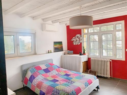 - une chambre avec des murs rouges et blancs et un lit dans l'établissement South of France Villa Family Home, à Vendargues
