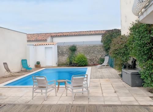 - une piscine avec 2 chaises et une table dans la cour dans l'établissement South of France Villa Family Home, à Vendargues