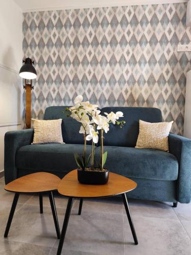 un salon avec un canapé bleu et une table dans l'établissement T2 Cyprien, Climatisé, piscines, resto, 5mn plages, à Lecci