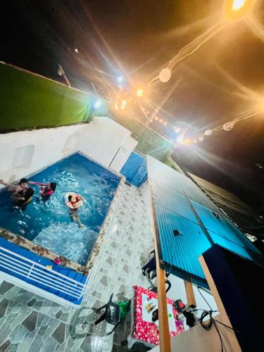 a pool with two people in it with an umbrella at Hadiqah event venue in Mangangpico