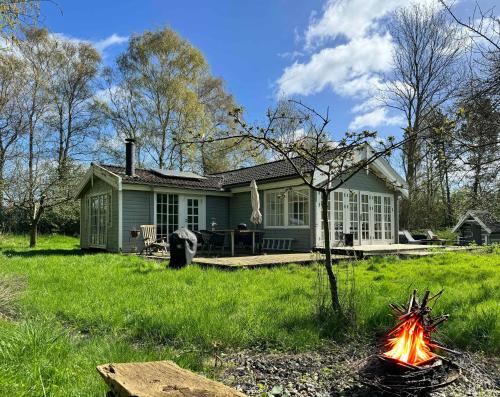 a house with a fire in front of it at Villa Betula Nature Gem At Hårbølle Harbor in Askeby