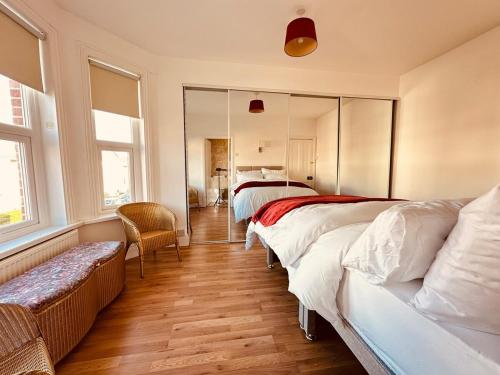 a bedroom with two beds and a mirror at Spacious Double Bedrooms for Family, Friends and Work-Bournemouth Stay in Bournemouth