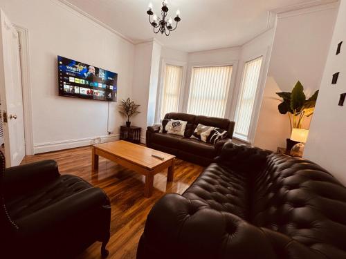a living room with a couch and a table at Spacious Double Bedrooms for Family, Friends and Work-Bournemouth Stay in Bournemouth