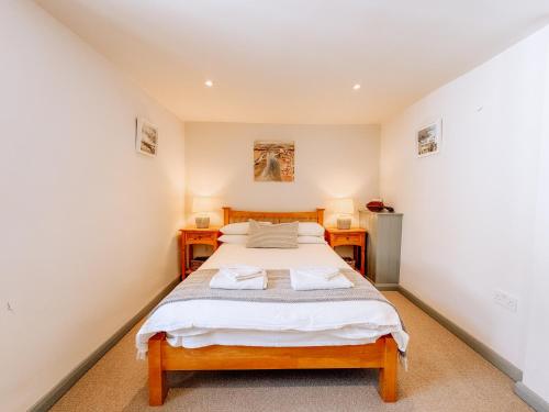 a bedroom with a bed and two night stands at Route 2 Apartments in Topsham