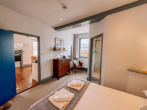a bedroom with a bed and a dresser and a mirror at Route 2 Apartments in Topsham