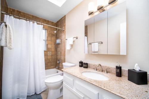 a white bathroom with a toilet and a sink at Private Heated Pool Arcade Games Sleeps 10 Jacksonville Home in Jacksonville