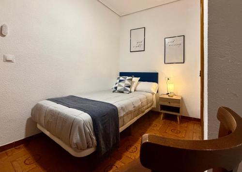 a small bedroom with a bed and a table at A R Benjamín in Artana