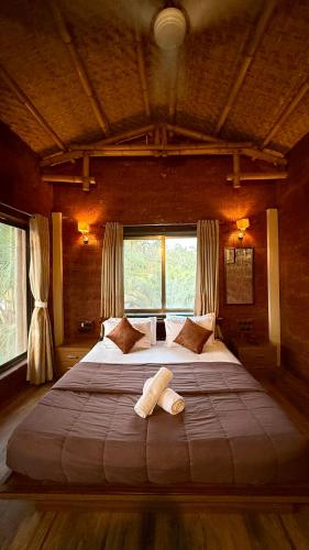 a large bed in a room with a large window at Kashid Boutique Resort in Sarne