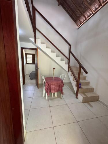 a dining room with a table and a staircase at Chalés serra linda in Bananeiras