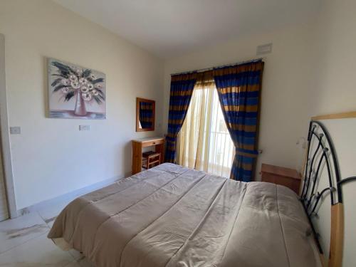 a bedroom with a bed and a window at Acciola Mimosa by Horizon Apartments Gozo in Qbajjar